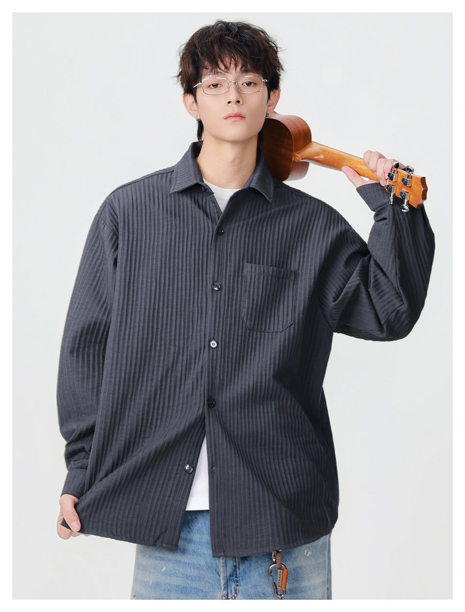 Model wearing a dark charcoal ribbed button-up shirt with a chest pocket, shown from the front.
