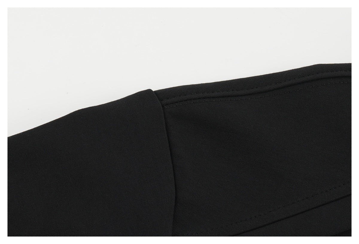 Close-up of a black shirt's shoulder seam and sleeve attachment.