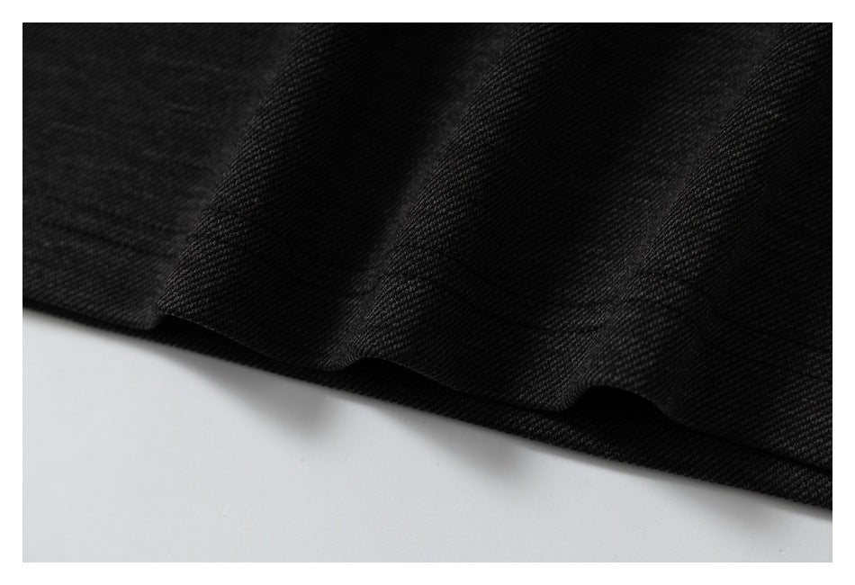 Close-up of the black garment's folded hem and diagonal knit texture.