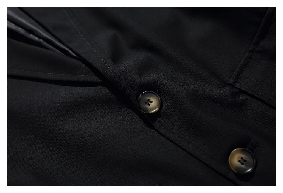 Close-up of the black blazer's front seam and two dark four-hole buttons.