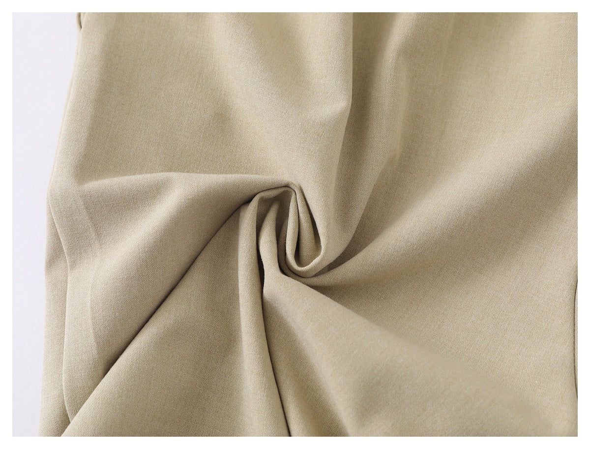 Close-up of beige fabric gathered into folds, showing its fine, even weave.