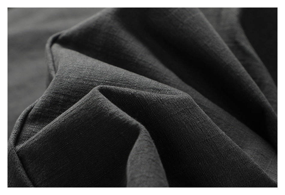 Macro view of the dark charcoal pants' woven fabric and folds.