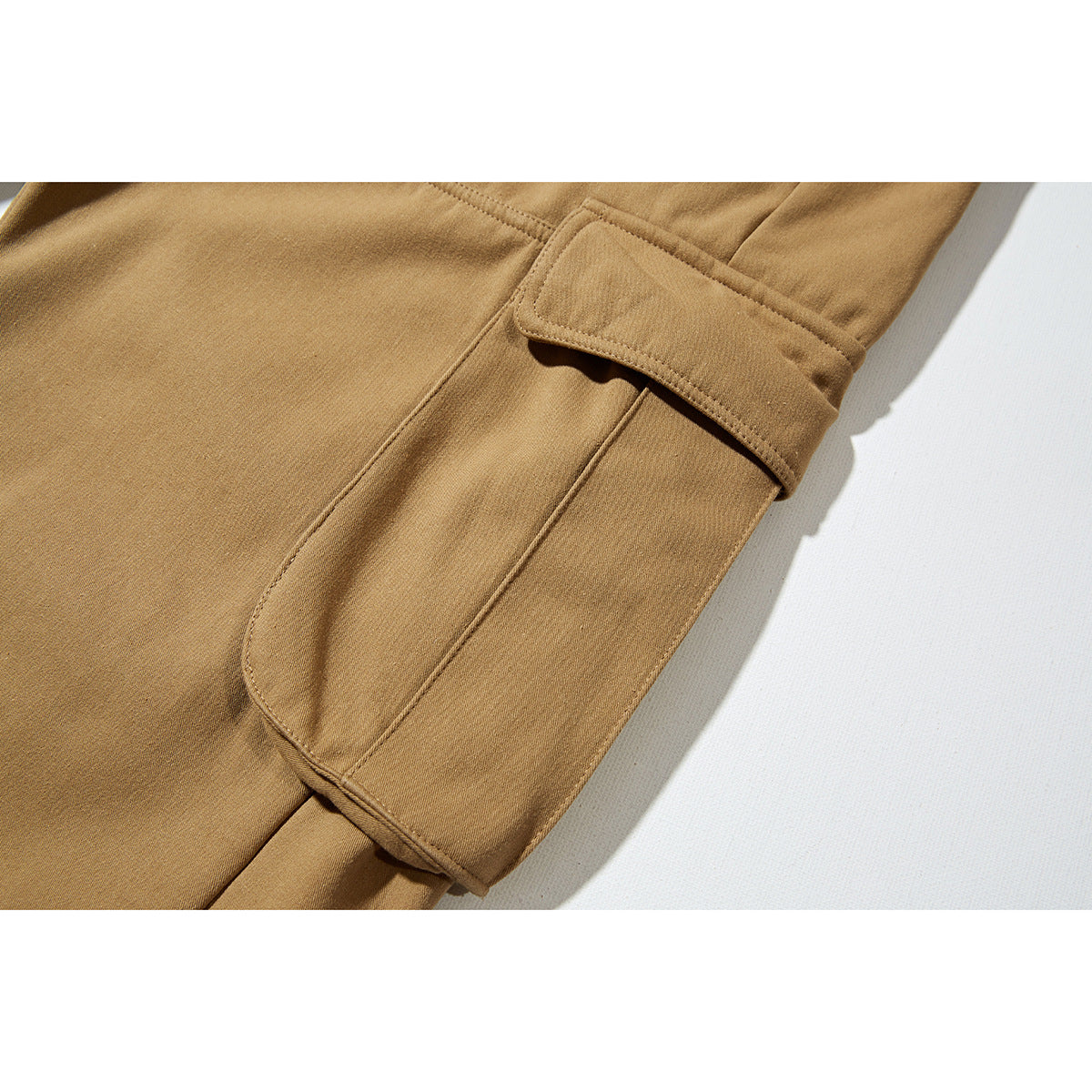 Close-up of a tan pant leg with a large flap cargo pocket.