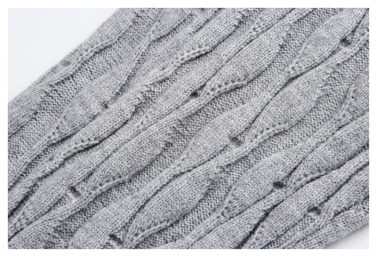 Close-up highlighting the raised cable-knit pattern on gray sweater fabric.