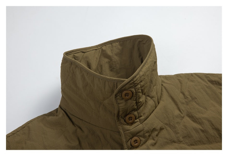 Close-up of an olive-brown quilted jacket's stand collar with three brown buttons.