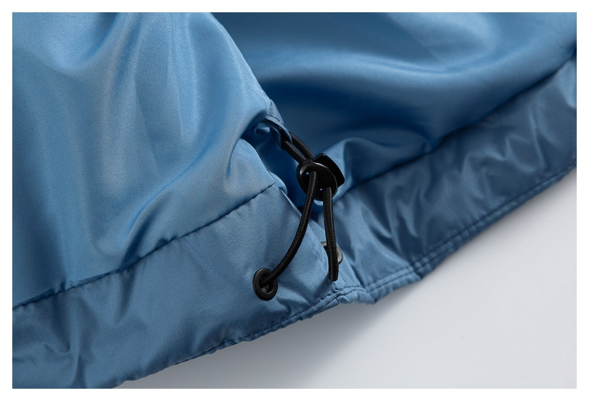 Close-up of the blue jacket hem with a black elastic drawcord and cord lock.