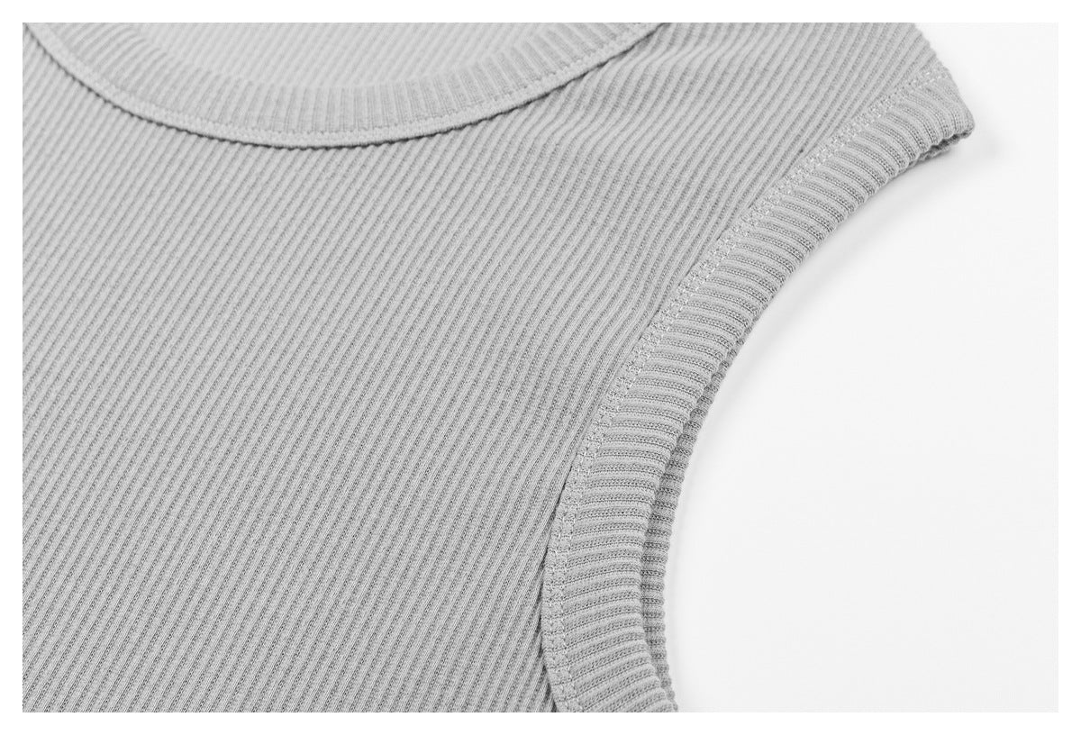 Close-up of the light gray ribbed top's neckline, fabric, and bound armhole edge.