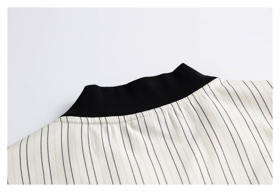 Close-up of a black ribbed collar on cream fabric with narrow dark stripes.