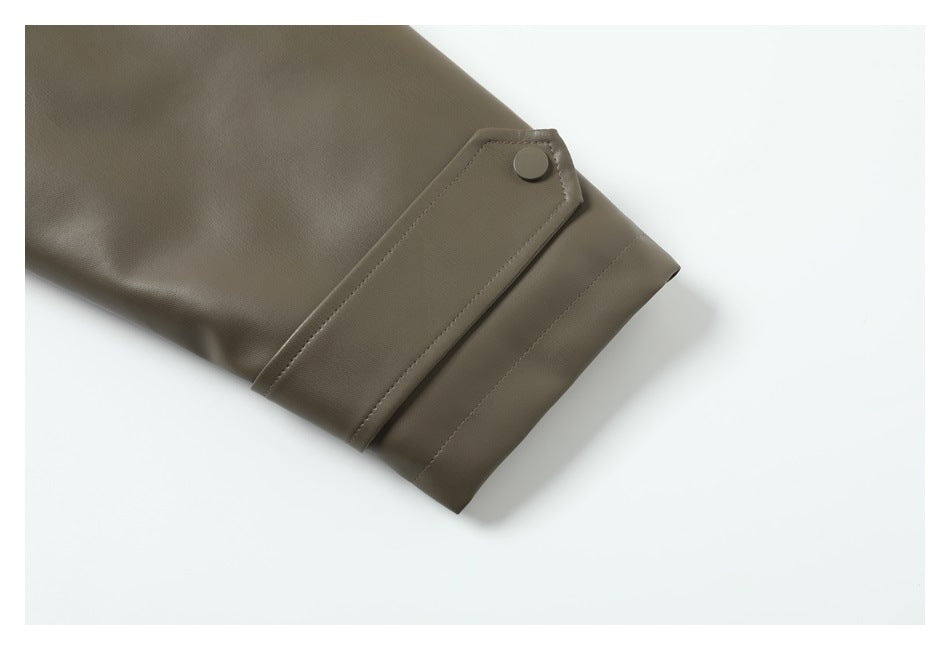 Close-up of an olive-brown jacket sleeve cuff with a snap-tab closure.