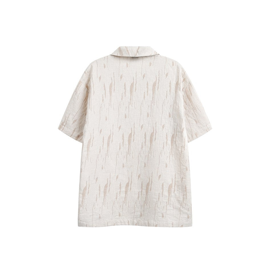 Back view of cream short-sleeve shirt with tan abstract vertical streak pattern and slightly longer back hem