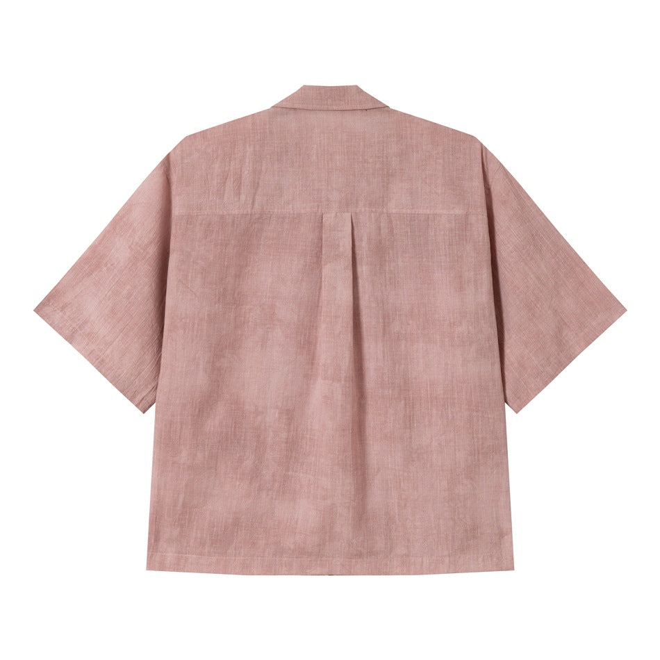 Back view of dusty pink short-sleeve shirt showing yoke seam and center box pleat on white background