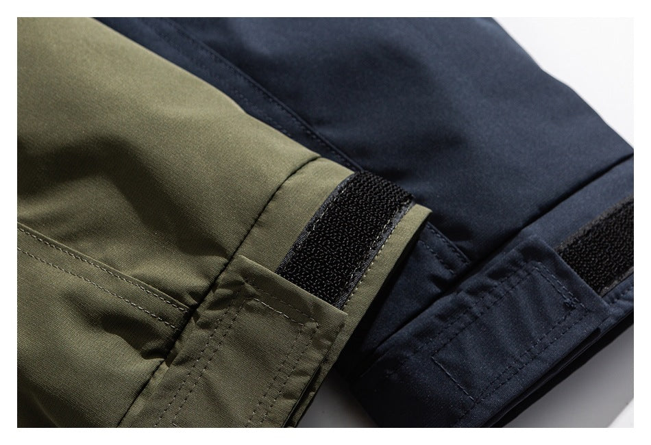 Close-up of olive and navy jacket cuffs with black hook-and-loop adjustment tabs.