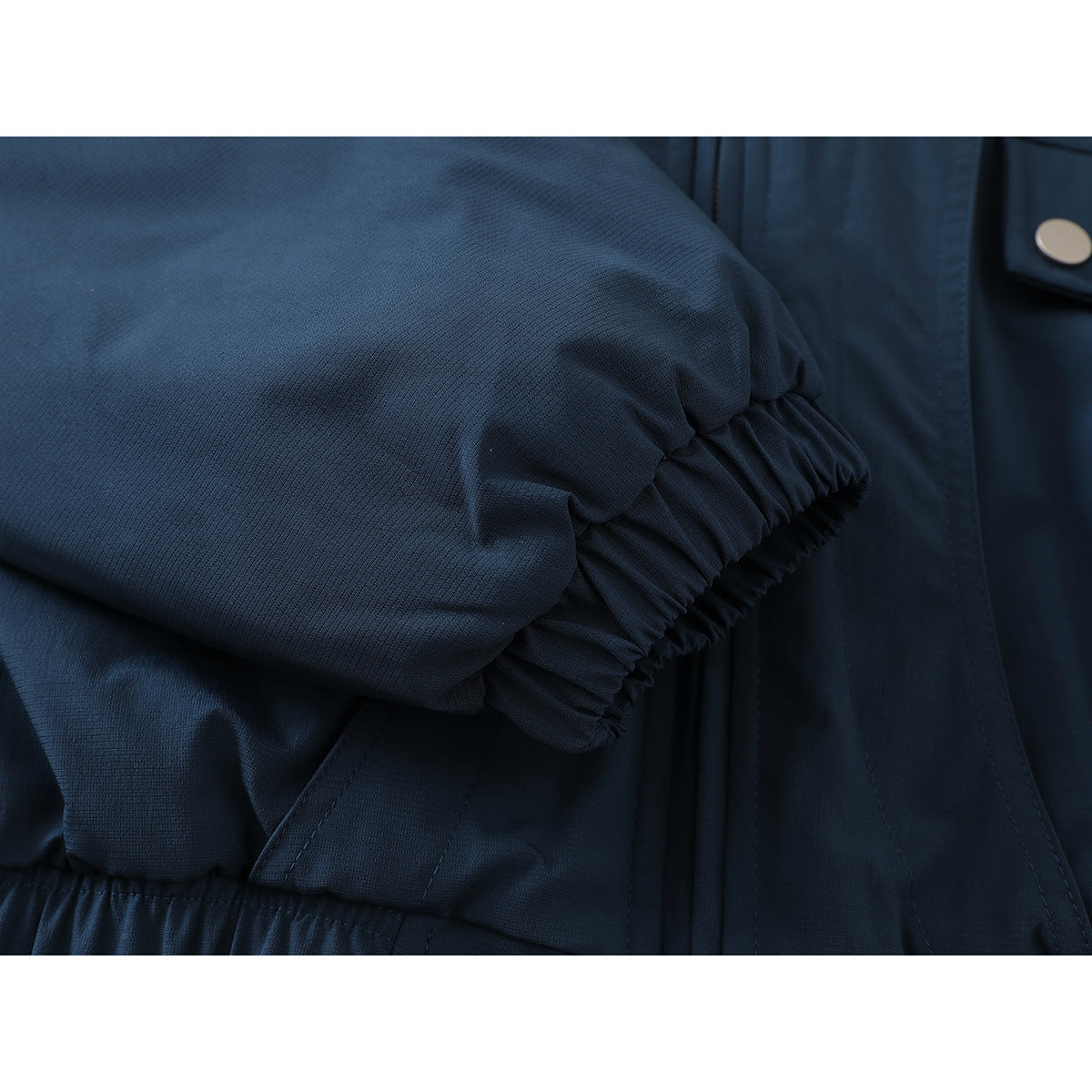Close-up of a dark navy jacket sleeve with a gathered elastic cuff.