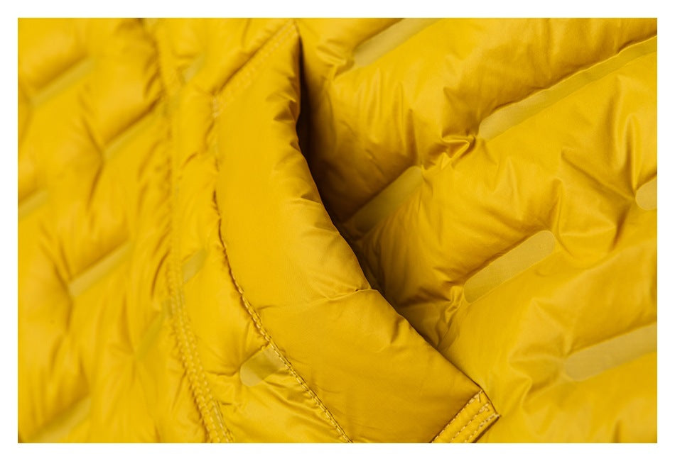 Close-up of a mustard-yellow padded jacket showing quilted panels and a stitched edge.