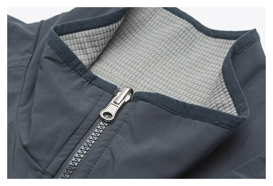 Close-up of the dark charcoal garment’s zip-front collar, showing a light gray textured inner lining.
