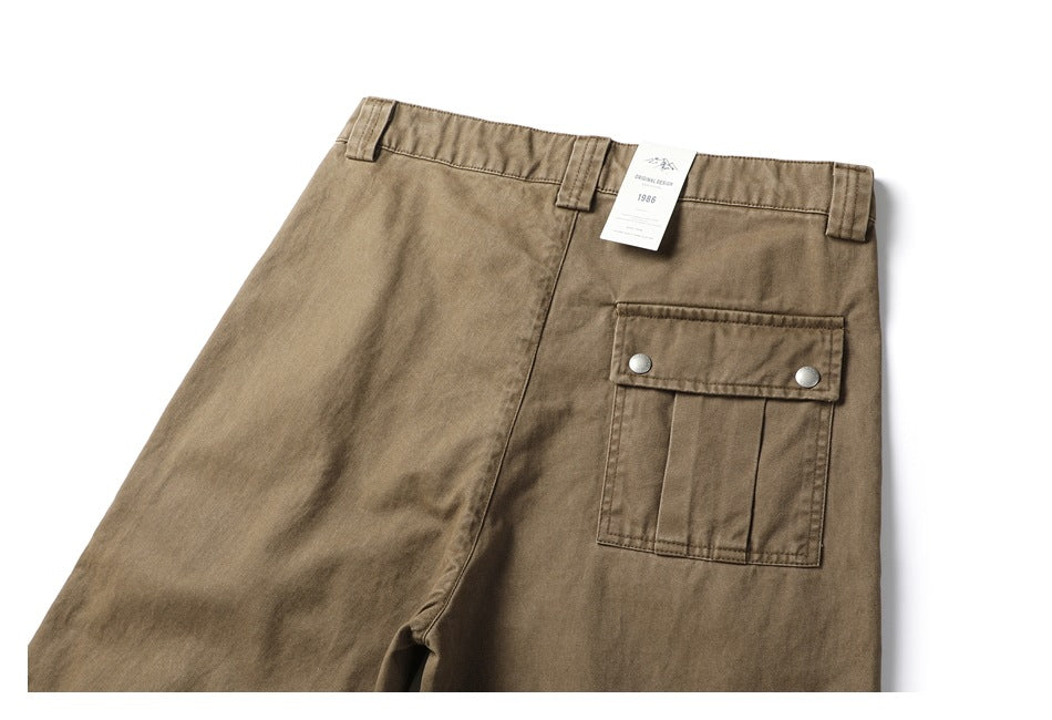 Front view of khaki-brown trousers with belt loops and a large flap cargo pocket with two metal snaps.