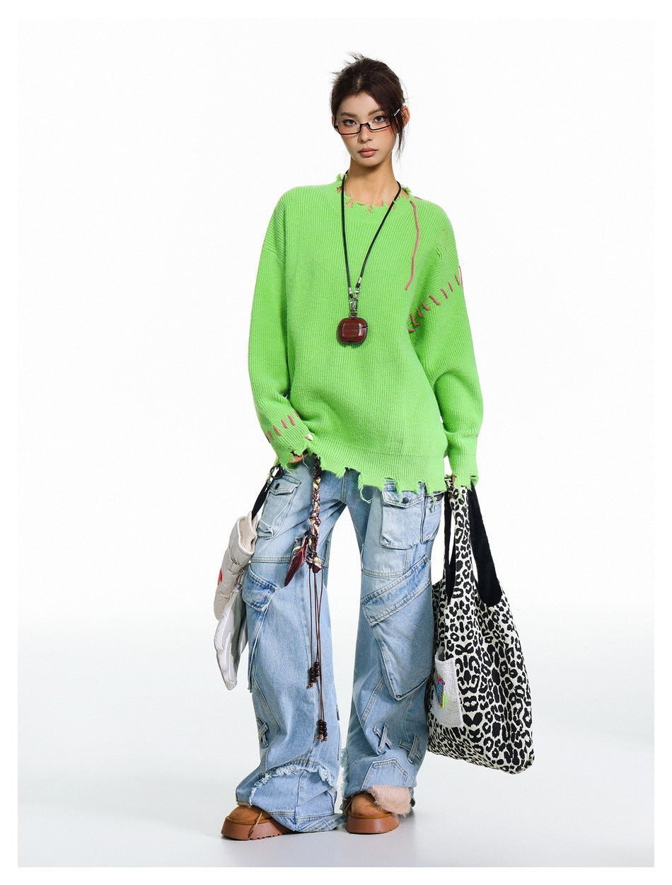 Full-length view of model in green frayed-edge sweater, wide-leg light-wash cargo jeans and a leopard-print tote