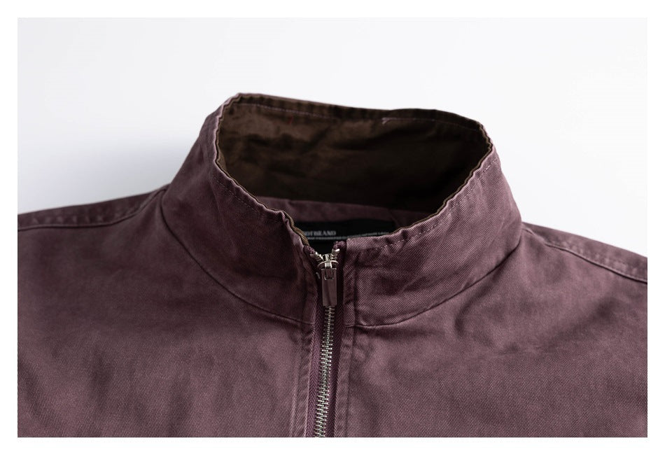 Close-up of a plum jacket's stand collar and centered metal front zipper.