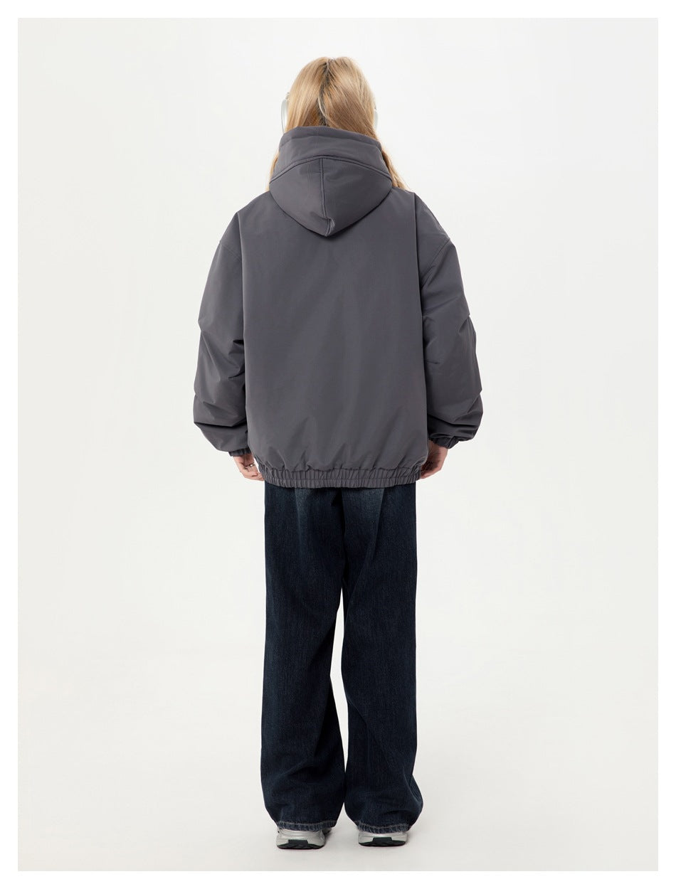 Back view of a model wearing a charcoal hooded jacket with an elastic hem and cuffs.
