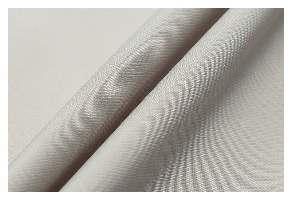 Close-up showing the fine woven texture and drape of light beige fabric.