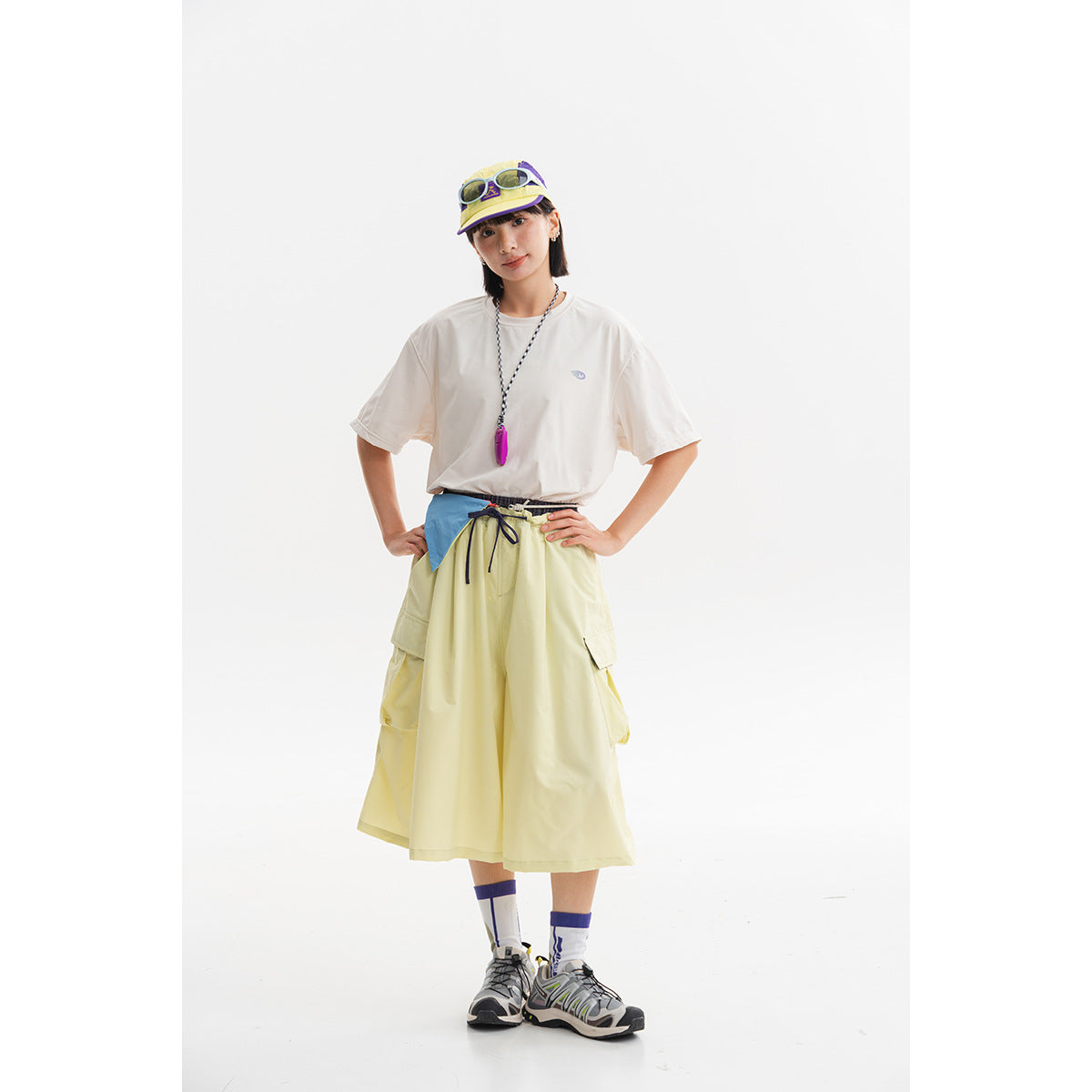 Model wearing an oversized white T-shirt and pale yellow wide midi cargo skirt with sneakers.