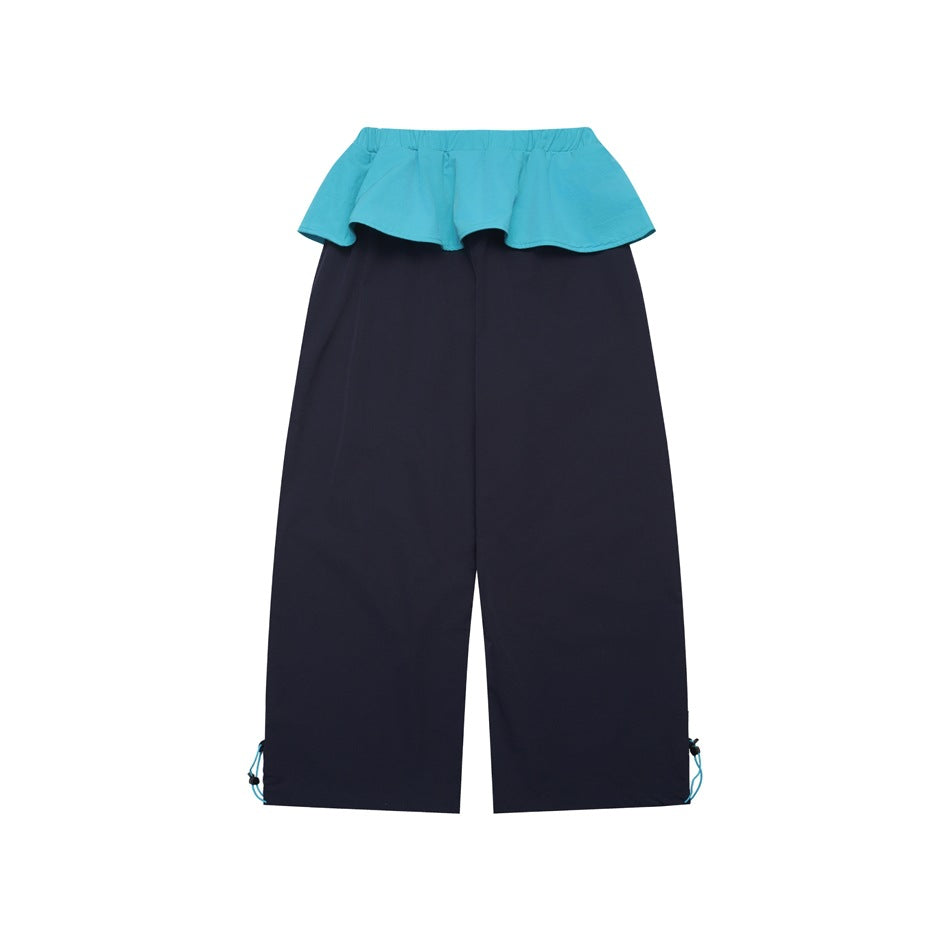 Front view of navy wide-leg pants with a bright turquoise flounced waistband and adjustable cords at the hems.