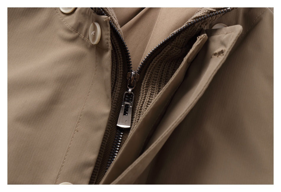 Close-up of the tan coat's partially unzipped front, showing the knit inner layer and placket.