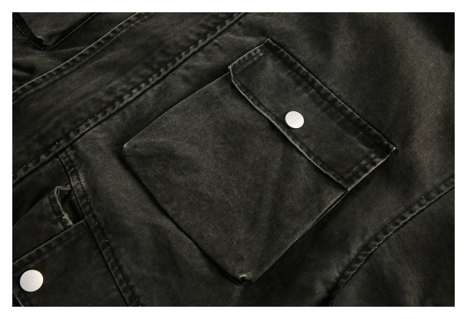 Close-up of a large snap-fastened flap pocket on the dark washed jacket.