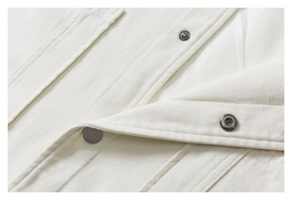 Close-up of an off-white garment placket with dark metal snap fasteners.