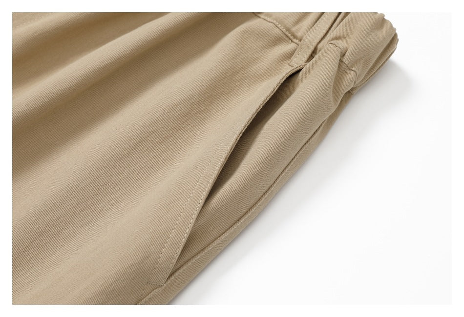 Close-up of a slanted pocket opening and stitching on the tan pants.