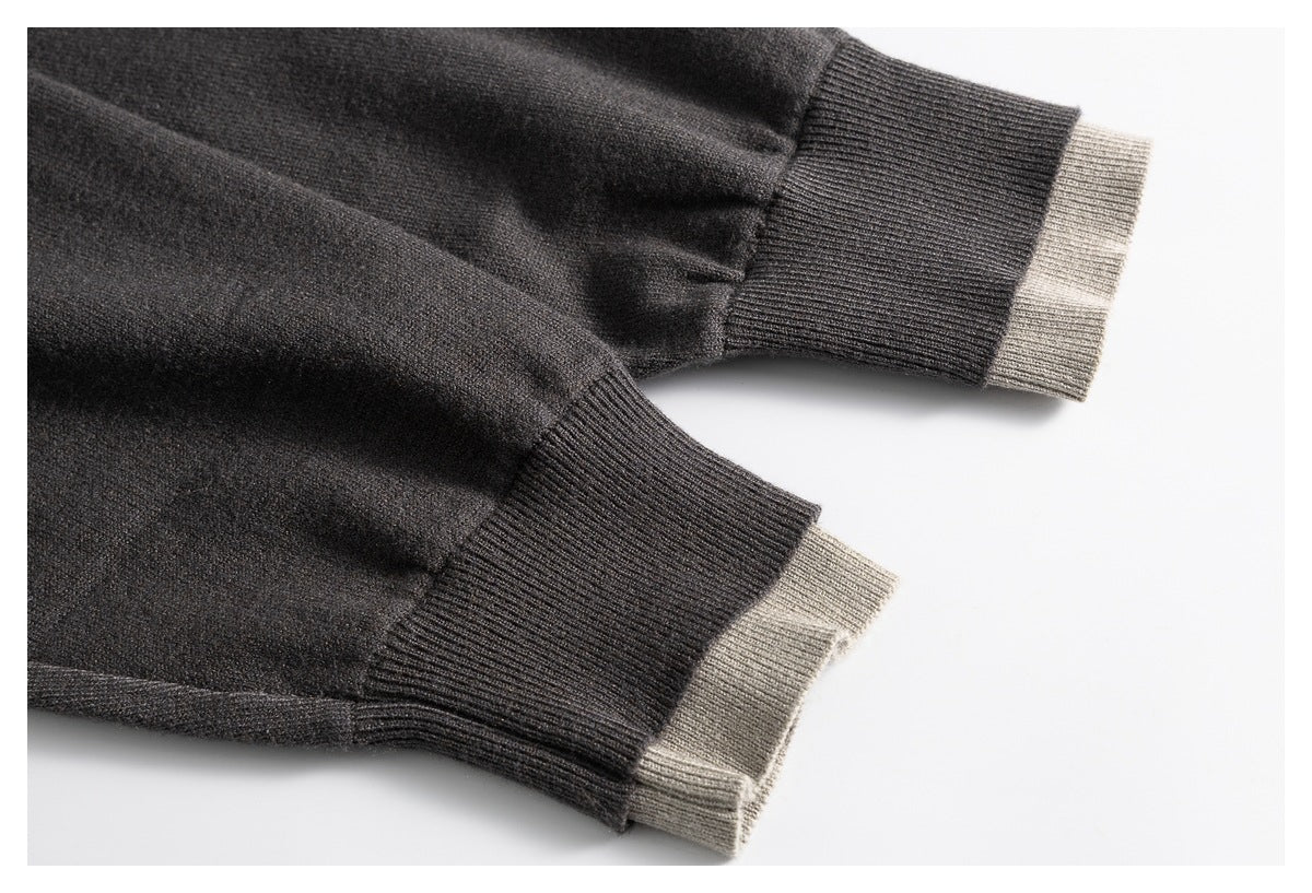 Close-up of the charcoal sweater's sleeves and ribbed cuffs, with taupe knit trim peeking out at the ends.