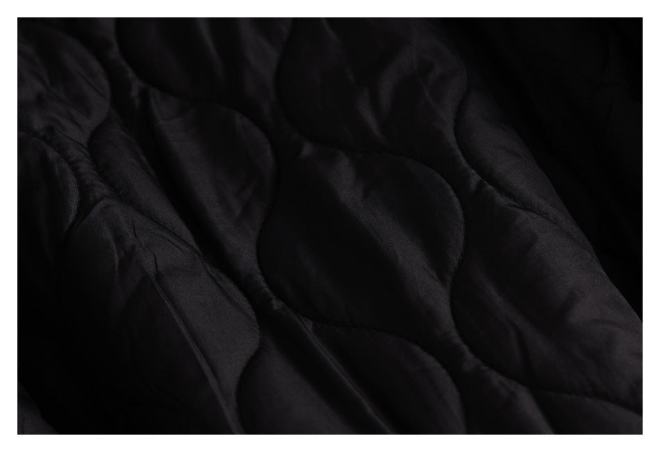 Close-up of black quilted lining with curved stitched sections.