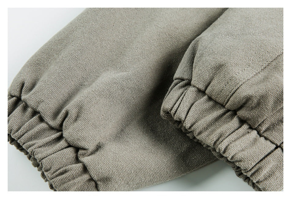 Close-up of gray-khaki fabric gathered into elasticated edges, showing the stitching and construction.