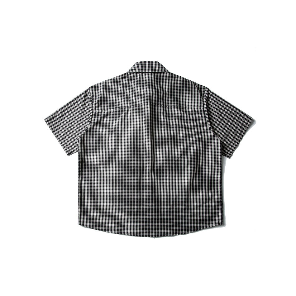 Back view of a black-and-white plaid short-sleeve button-up shirt laid flat.