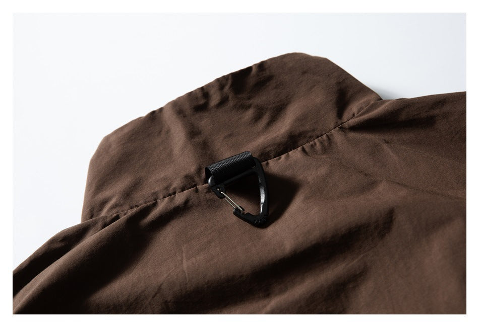 Close-up of a black attachment loop on the back of a dark brown jacket.