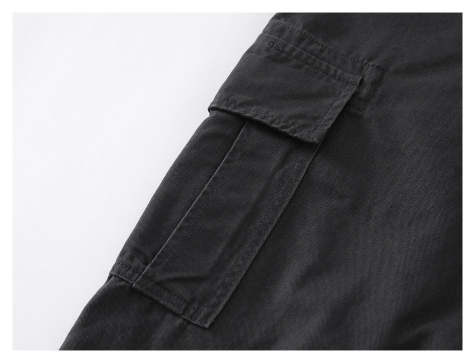 Close-up of a black cargo pant leg with a flap pocket and visible stitching.