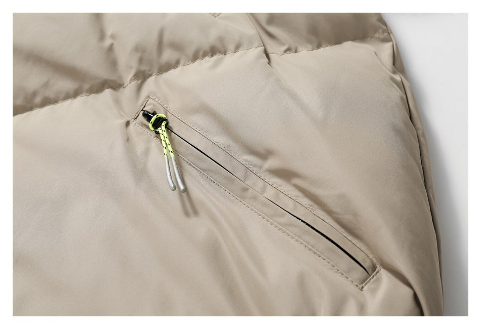 Close-up of a beige jacket's diagonal zip pocket with a bright neon yellow-green cord pull.