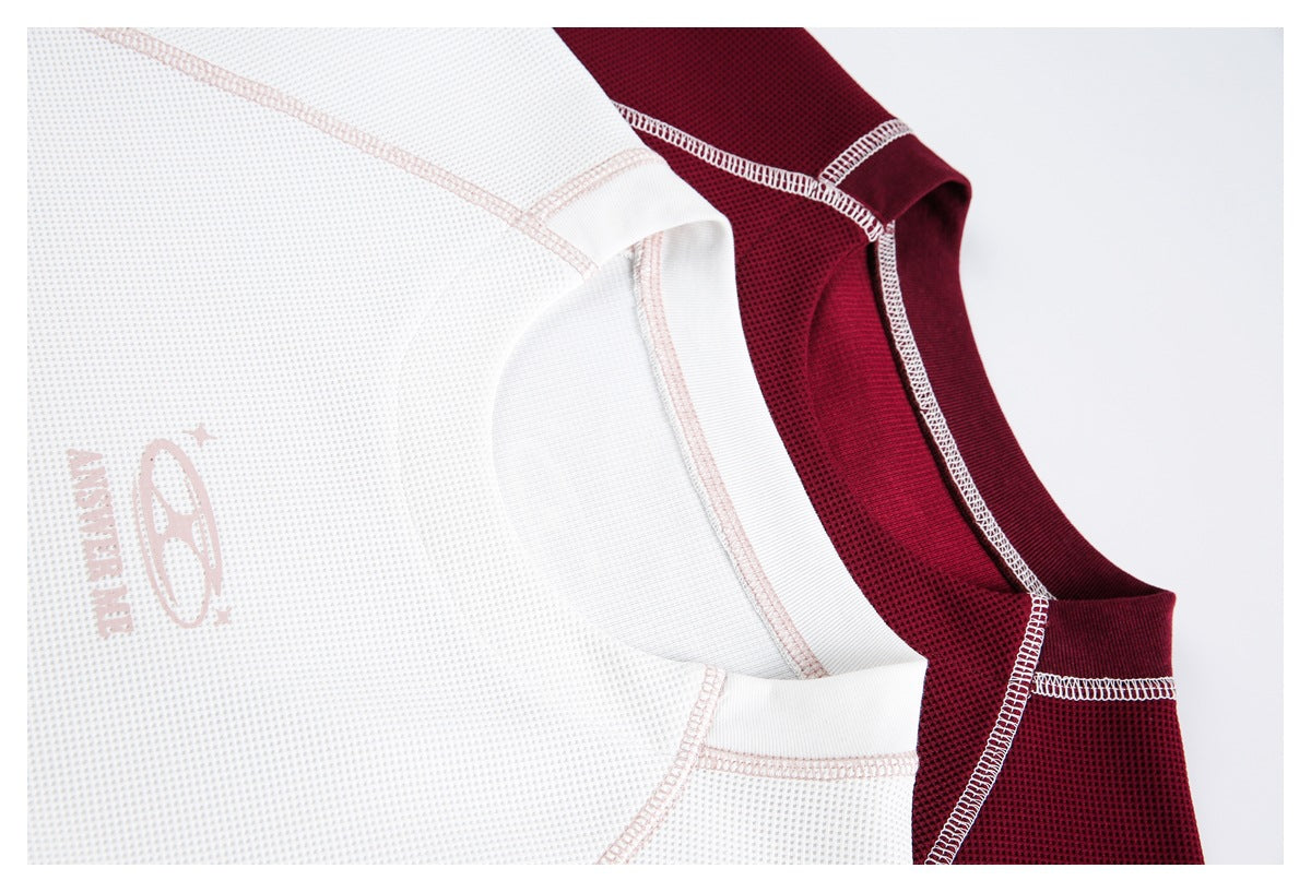Close-up of white and burgundy shirts showing textured fabric, contrast seams, and collars.