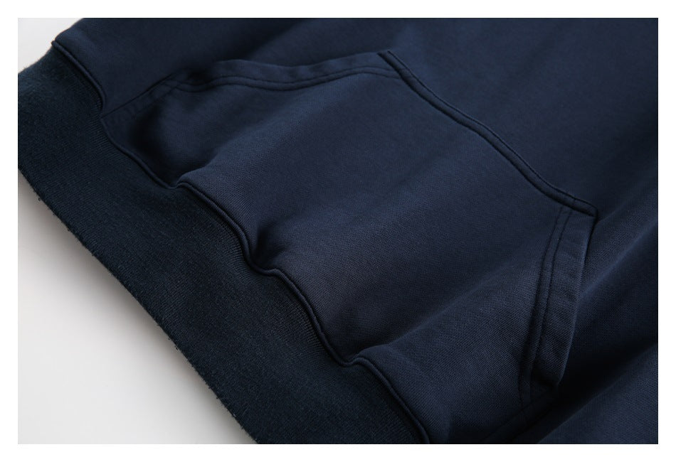 Close-up of the navy sweatshirt's front kangaroo pocket and ribbed hem.
