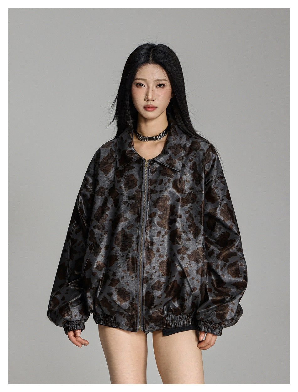 Model wearing a gray jacket with a brown and black irregular print, front zipper, collar and gathered cuffs.