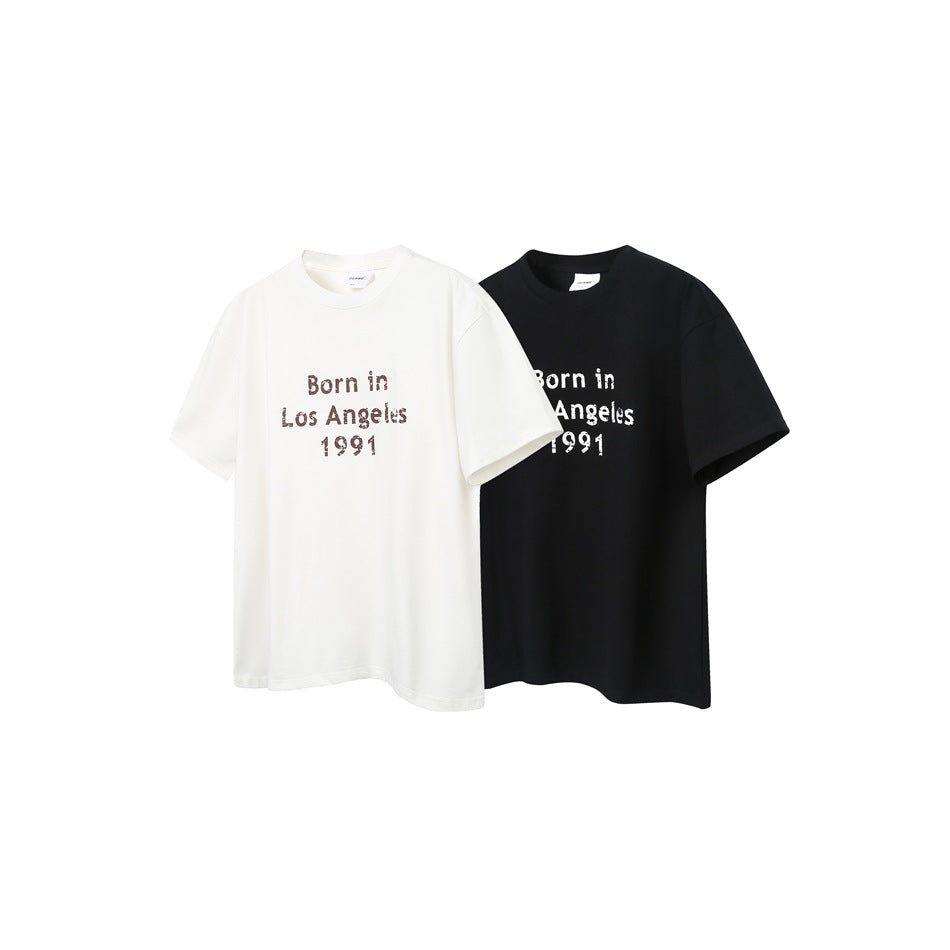 White and black short-sleeve crew-neck T-shirts with “Born in Los Angeles 1991” chest prints.