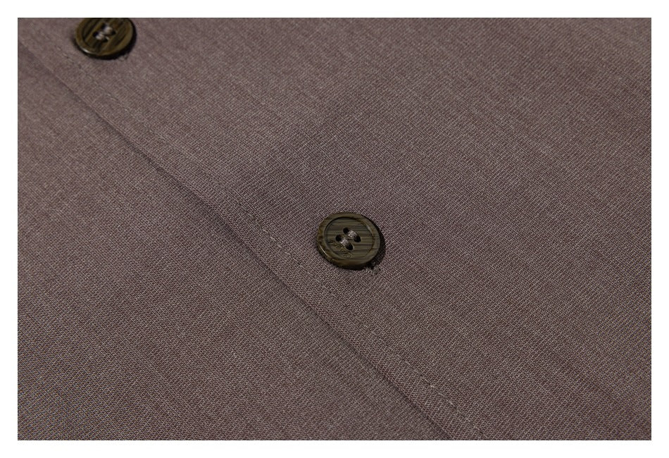 Close-up of taupe-brown garment fabric with a stitched placket and dark buttons.
