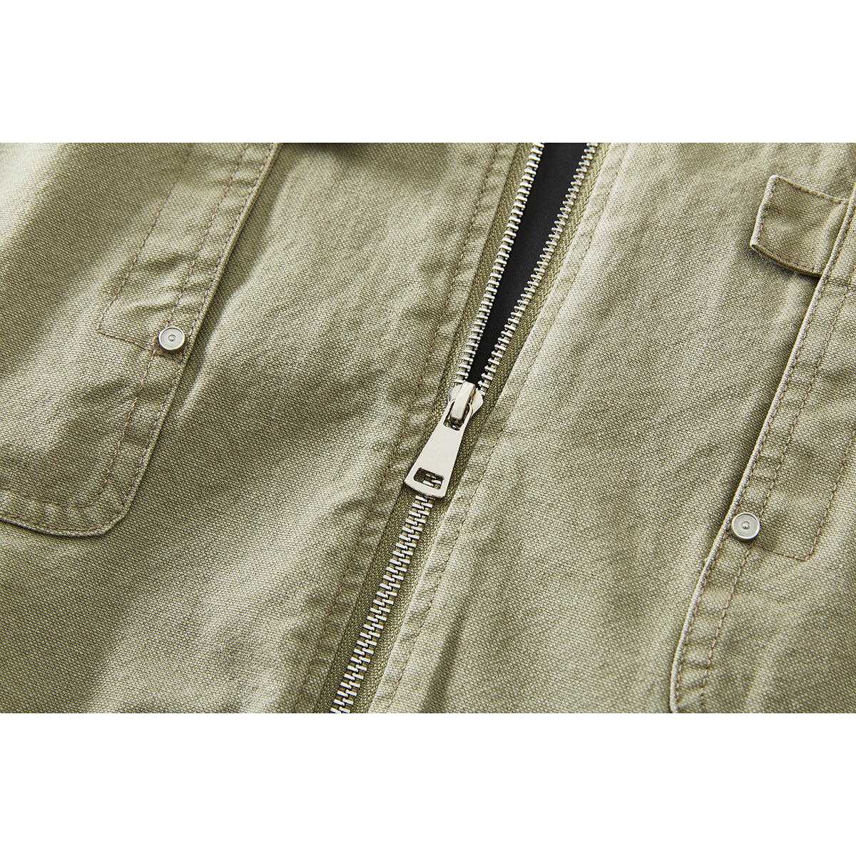 Close-up of the olive-khaki jacket front, showing its zipper and buttoned chest pockets.