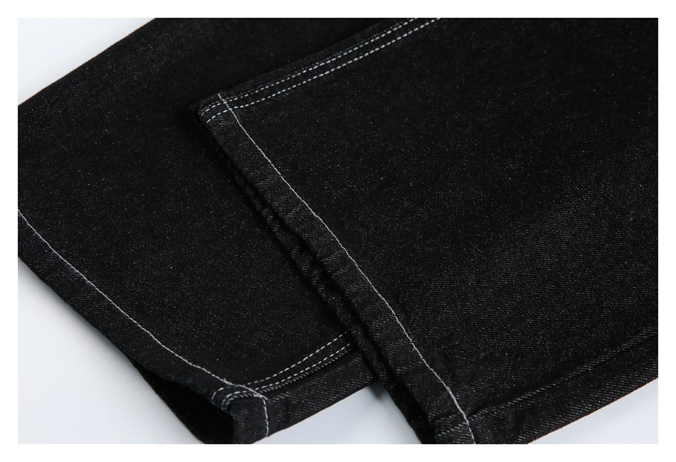 Close-up of black denim with contrasting white stitching along a folded seam.
