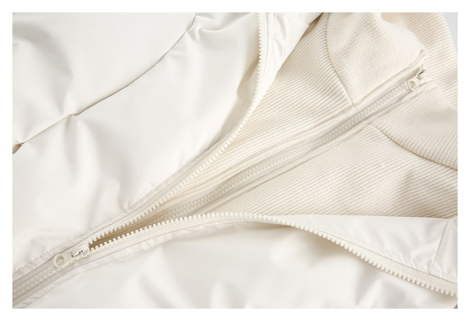Close-up of the ivory jacket's front zippers and textured knit inner collar.