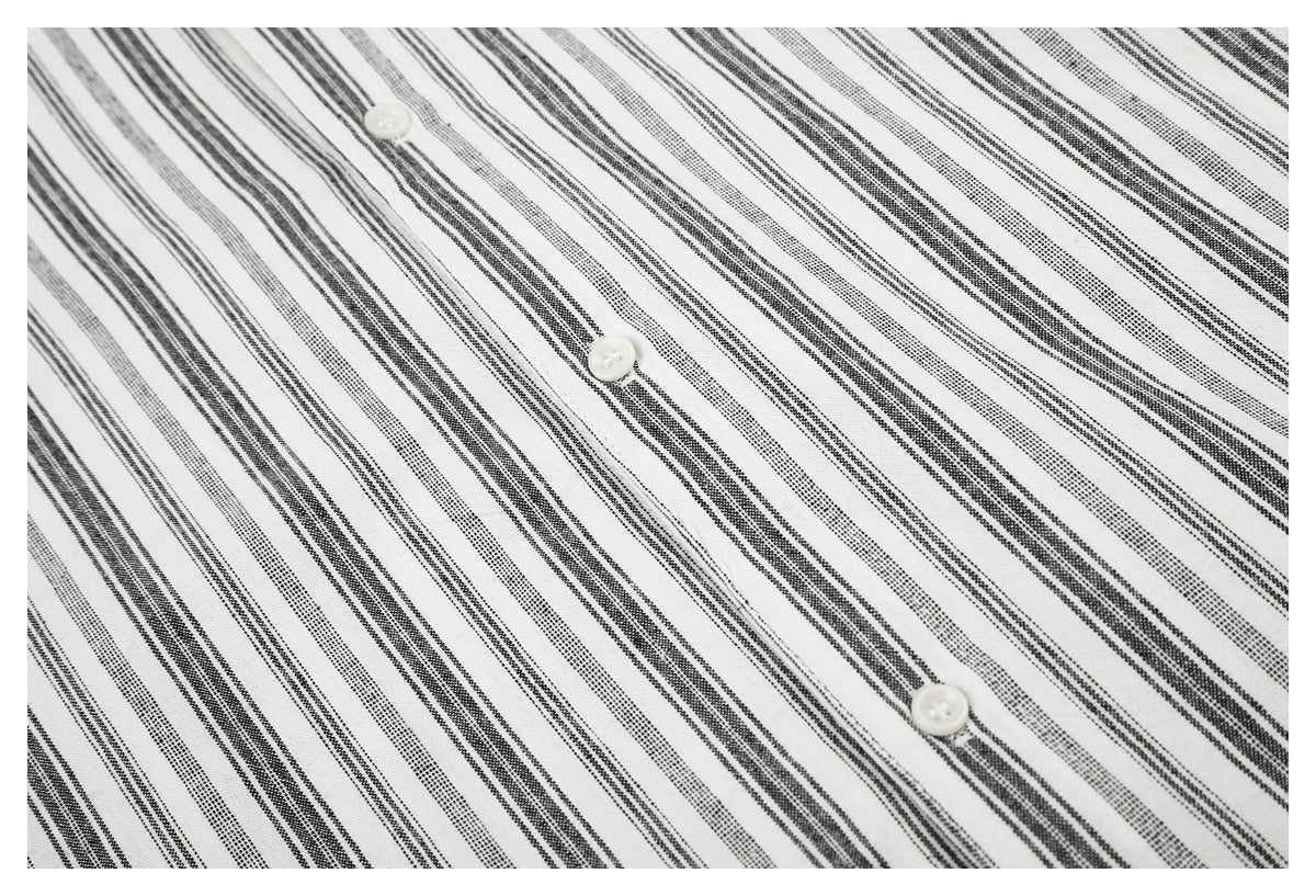Close-up of the black-and-white striped shirt fabric and white buttons along the placket.
