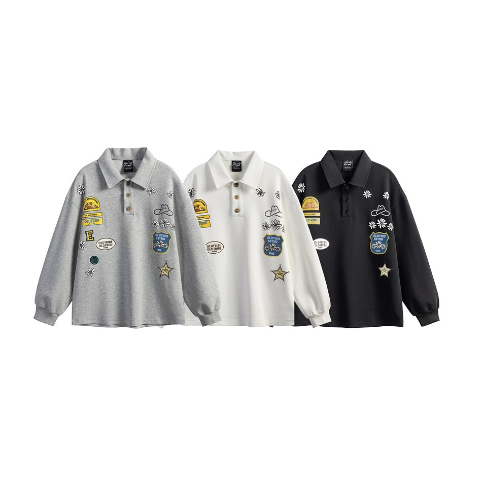 Three collared long-sleeve pullovers with graphic patches and daisy motifs, shown in gray, white, and black.