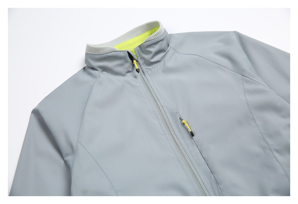 Close-up of a light gray jacket's zip front and stand collar, showing bright lime collar lining and zipper pulls.