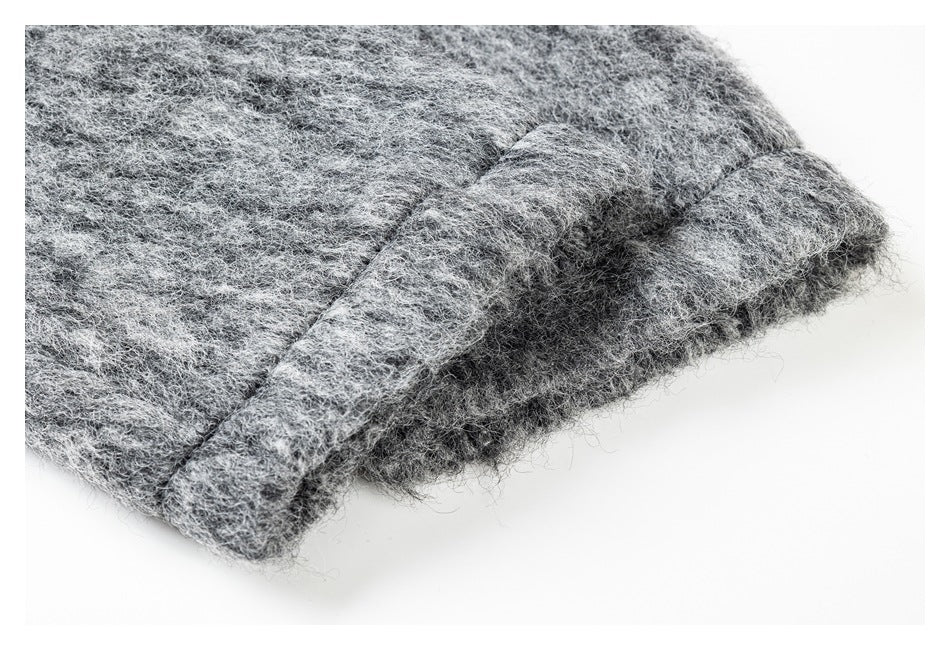 Close-up of a folded, stitched edge on a light gray fuzzy garment.