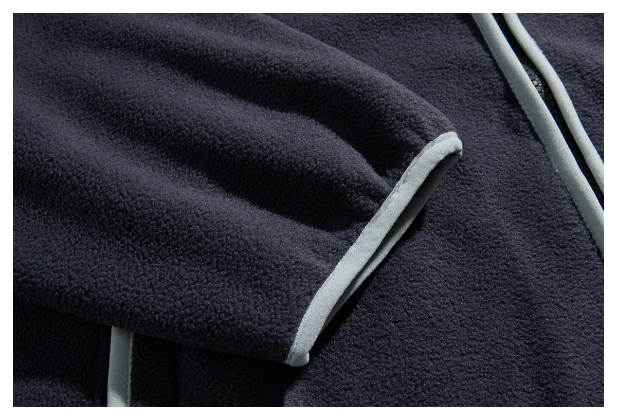 Close-up of a dark navy fleece sleeve edge finished with pale gray binding.